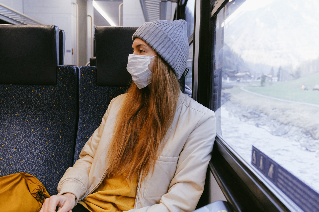 Girl with a mask on a train